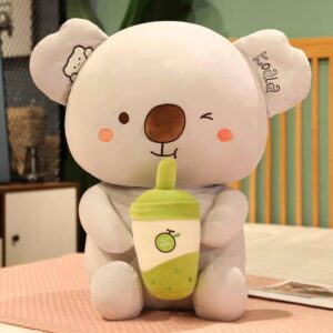 Cute grey koala plush toy holding a yellow milk bottle with mango print, soft stuffed animal doll for kids and gifting.