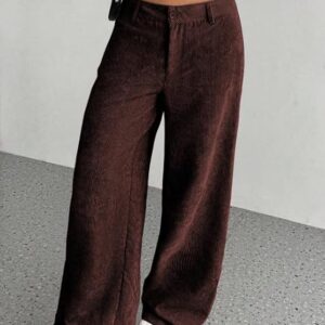 Person wearing loose-fit brown corduroy wide-leg pants paired with a white long-sleeve cropped top and white sneakers.